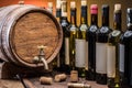 Wine bottles in row and oak wine keg Royalty Free Stock Photo