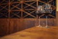 Wine bottles on a wooden shelf. Wine bar. Two glasses with red wine on wooden background Royalty Free Stock Photo