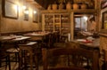 Focus on tables inside retro restaurant with wooden vintage furniture, plates, wine bottles