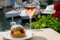 Wine and cake of French Riviera, glasses of cold rose Cote de Provence wine and Tarte Tropezienne cake in yacht harbour of Port