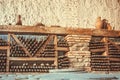 Wine cellar with many dusty glass bottles and rustic wooden shelves on stone walls of rural storage of winery Royalty Free Stock Photo