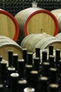 Wine cellar with wooden barrels and filled glass bottles 8 Royalty Free Stock Photo