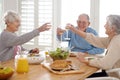 Wine, cheers and senior friends at lunch in home with smile, celebration and bonding in retirement. Food, drinks and Royalty Free Stock Photo