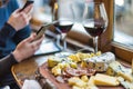 wine and cheese platter, person chatting on phone by window