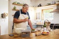 Wine, cooking and senior man in the kitchen preparing a meal for dinner or lunch at his home. Happy, retirement and Royalty Free Stock Photo