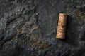 Wine cork on textured rock surface. Dark moody style suitable for background or creative projects. High-resolution image Royalty Free Stock Photo