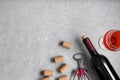 Wine corks, bottle, glass of drink and corkscrew on light grey table, flat lay. Space for text Royalty Free Stock Photo