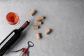 Wine corks, bottle, glass of drink and corkscrew on light grey table, flat lay. Space for text Royalty Free Stock Photo