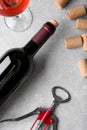 Wine corks, bottle, glass of drink and corkscrew on light grey table, flat lay Royalty Free Stock Photo