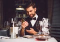 Wine critic holding bottle of scarlet drink with smile