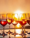 Different kind of wine in glasses on table on blurred seascape sunset background with copy space