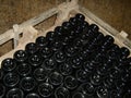 Wine dusty bottles upside down in a box for storing and brewing wine. Wine cellar equipment. The process of wine making Royalty Free Stock Photo