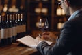 Wine expert tasting red wine with notes Royalty Free Stock Photo