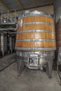 Wine fermentation tank made of oak wood. Steel vats for wine fermentation in winemaking factory. Oak wood wine vats in a row