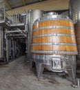 Wine fermentation tank made of oak wood. Steel vats for wine fermentation in winemaking factory. Oak wood wine vats in a row