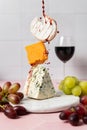 Wine fountain on levitating soft goat cheese, cheddar and blue stilton with grape Royalty Free Stock Photo