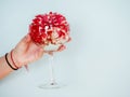 Wine glass with beautiful red color flower in a woman hand. Light blue background. Selective focus. Copy space Royalty Free Stock Photo