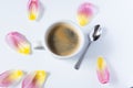 Hot coffee surrounded by tulip petals