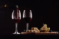 Wine glass and bottle, pear and grapes on black background