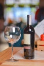 Wine glass and bottle of red wine on a wooden table over blurred background. Restaurant service, eating out concept Royalty Free Stock Photo