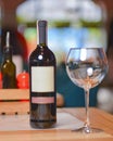 Wine glass and bottle of red wine on a wooden table over blurred background. Restaurant service, eating out concept Royalty Free Stock Photo