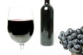 Wine glass close view with grapes and a bottle on the background Royalty Free Stock Photo