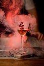 wine glass with drink decorated with red hearts stands on the bar and smoke around