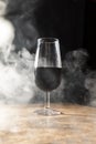 wine glass enveloped by white smoke with black background