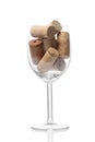 Wine glass full of wine cork stoppers isolated on white background with clipping path and copy space for your text Royalty Free Stock Photo