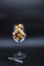 Wine glass full of many corks and corkscrew Royalty Free Stock Photo