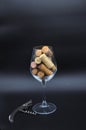 Wine glass full of many corks and corkscrew Royalty Free Stock Photo