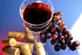 Wine glass, grapes and corks Royalty Free Stock Photo