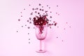 Wine glass with heart confetti on pink background. Top view. Valentines day and romantic love concept. Copy space Royalty Free Stock Photo