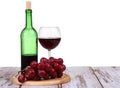 glass with red wine, bottle of wine and grapes isolated over white background Royalty Free Stock Photo