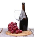 Wine glass with red wine, bottle of wine and grapes isolated over white background Royalty Free Stock Photo