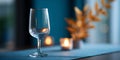 A wine glass sits on a table with candles and fall leaves in the background, creating an intimate atmosphere for dinner or drinks Royalty Free Stock Photo