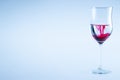 Wine glass of water with red color drop Royalty Free Stock Photo