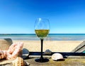 Restaurant  Beach Cafe Wine glass and women hat on wooden bench on beach blue sky white sand  green sea water summer holiday Royalty Free Stock Photo