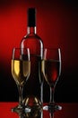 white wine bottle and wine glasses on dark red background Royalty Free Stock Photo