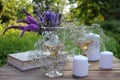 Wine glasses decorated with flowers, book, bouquet of lavender, veronica flowers in vase, candles on a wooden table Royalty Free Stock Photo