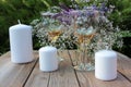 Wine glasses decorated with flowers, bouquet of lavender, veronica flowers in vase, candles on a wooden table in the summer garden Royalty Free Stock Photo