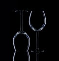 Wine glasses of different shapes and a bottle on a black background