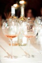 Two glasses with rose wine on the background of two wine bottles in a restaurant