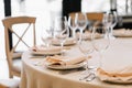 Wine glasses in the foreground. Wedding Banquet or gala dinner. The chairs and table for guests, served with cutlery and crockery