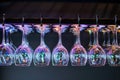 wine glasses hanging upsidedown on a rack with led highlights