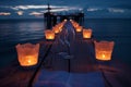 wine glasses between lit candles on pier, night setting Royalty Free Stock Photo