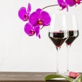 Wine glasses with natural red wine. on wooden table with orchids