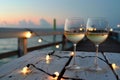 wine glasses on pier with string lights, evening mood Royalty Free Stock Photo