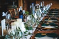 Wine glasses, plates, forks and green briefcases for the banquet. Rustic wedding table setting in fancy Canadian restaurant. Royalty Free Stock Photo