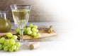 Wine and green grapes on rustic wood, corner background on white